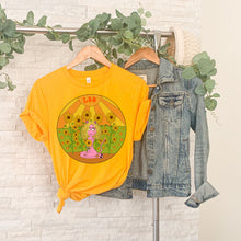 Load image into Gallery viewer, Gold Leo shirt hanging on a rack with leave and a denim jacket warm groovy color palette leo lion leo sunflower birth flower gifts for leos leo women
